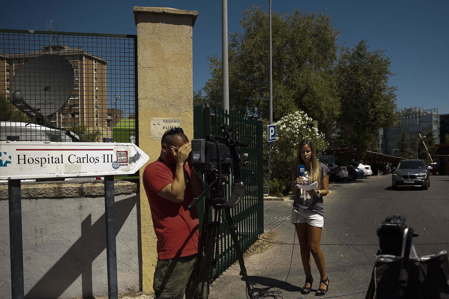 Journalists stand outside the main door of the Carlos III Hospital where Miguel Pajares, a Spanish priest who was infected with the Ebola virus while working in Liberia, was transferred after being evacuated to Spain.