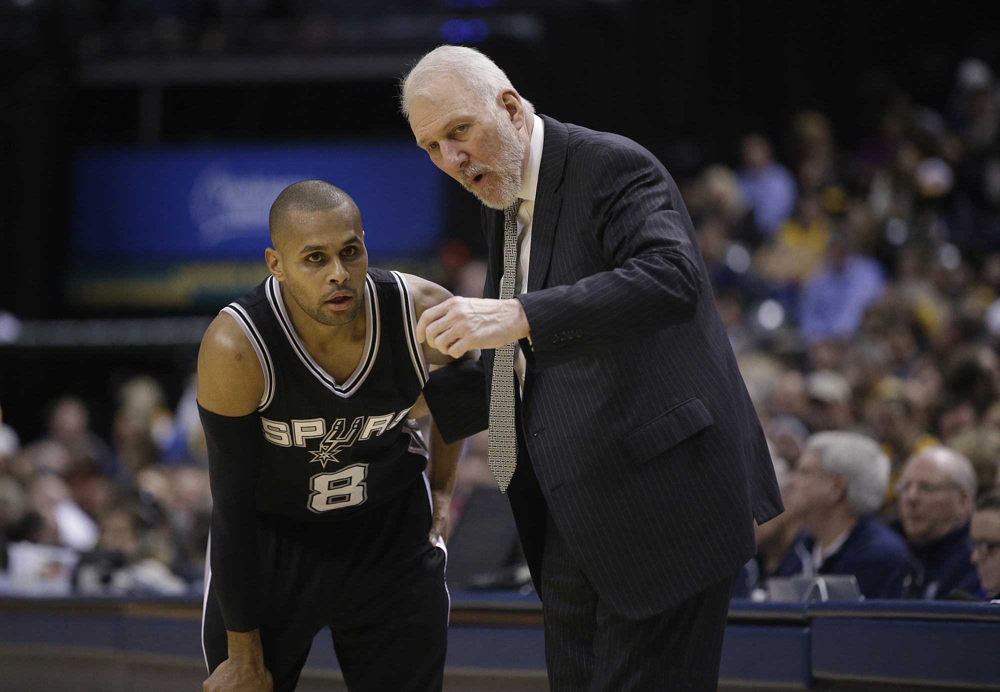San Antonio Spurs head coach Gregg Popovich talks with Patty Mills (8) during the second half against the Indiana Pacers on Monday, Feb. 9, 2015, in Indianapolis. San Antonio won the game 95-93. The win gave Popovich his 1,000th career win.