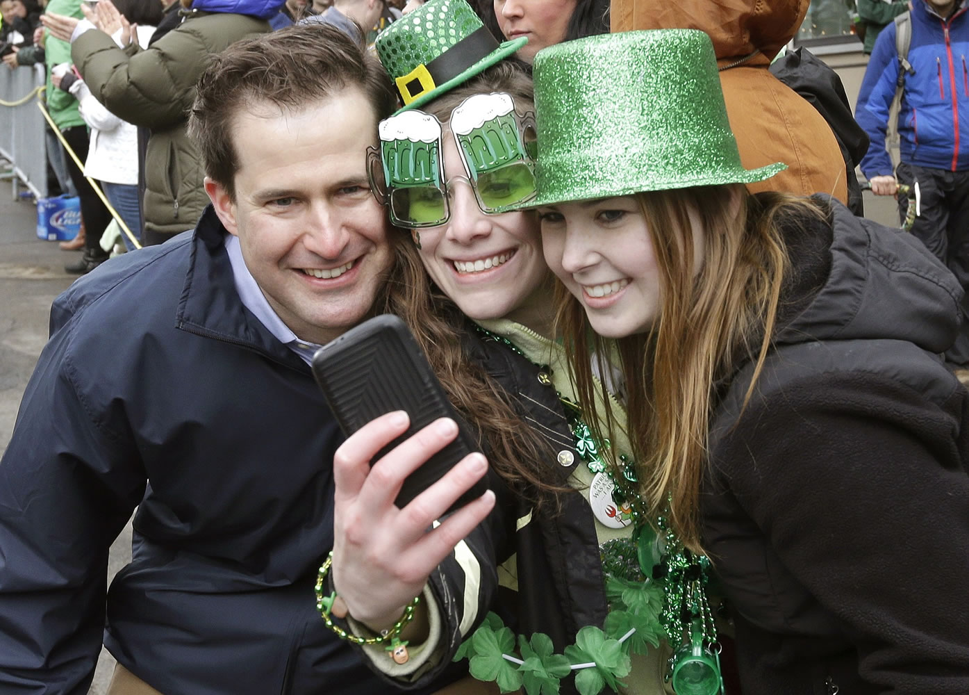 U.S. Rep. Seth Moulton, D-Mass., left, poses for a photo with spectators while marching Sunday in the St. Patrick's Day parade in Boston's South Boston neighborhood.