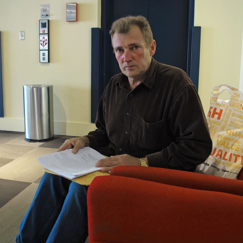 Yury Decyatnik poses for a photo as he holds his immigration paperwork in Seattle.