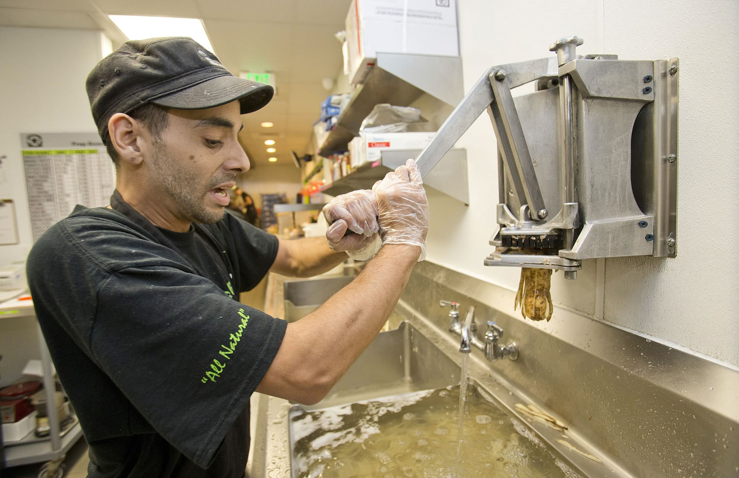 BurgerFi restaurant employee David Rivera makes french fries Tuesday at the store in Aventura, Fla. Companies such as the gourmet hamburger chain BurgerFi plan to nearly double in size from their existing 65 restaurants this year.
