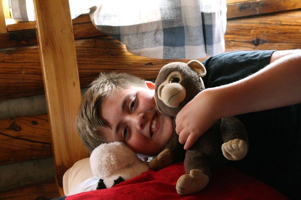 A junior camper holds his stuffed animal at a Sanborn Western camp in Florissant, Colo.