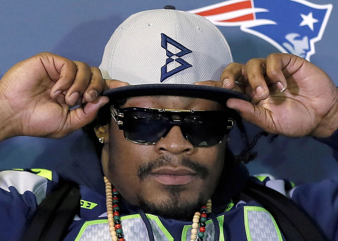 Seattle Seahawks' Marshawn Lynch adjusts his cap during an interview Thursday, Jan. 29, 2015, in Phoenix.