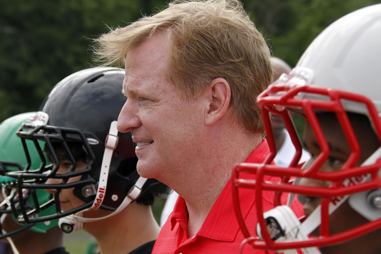NFL commissioner Roger Goodell, center, poses youth football players from the Akron Parents Pee Wee Football League after they received new helmets in Akron, Ohio.