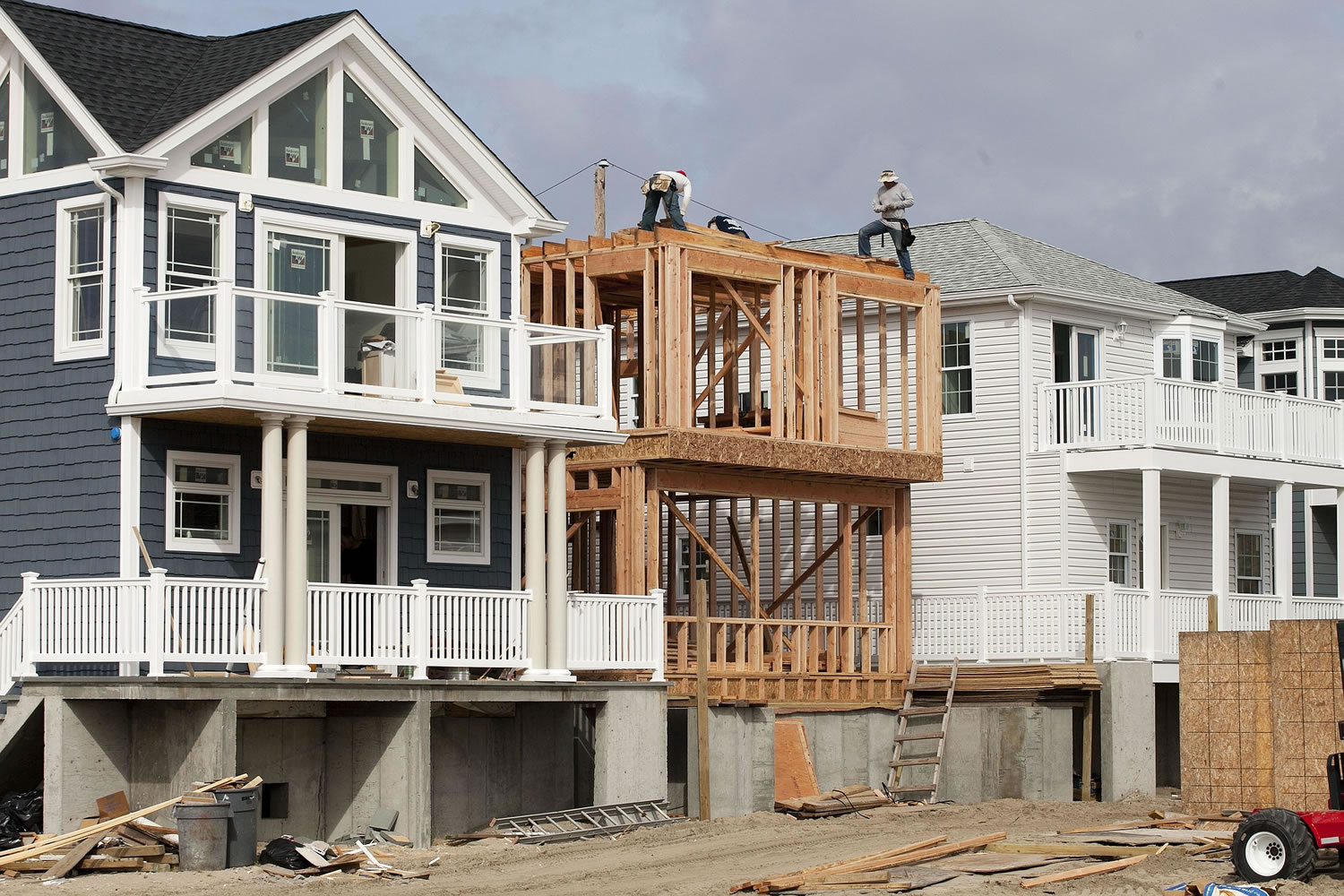 Carpenters work on a home under construction, center, between other new homes Oct. 15 in the Breezy Point neighborhood of the Queens borough of New York, an area hard hit by Superstorm Sandy in 2012.