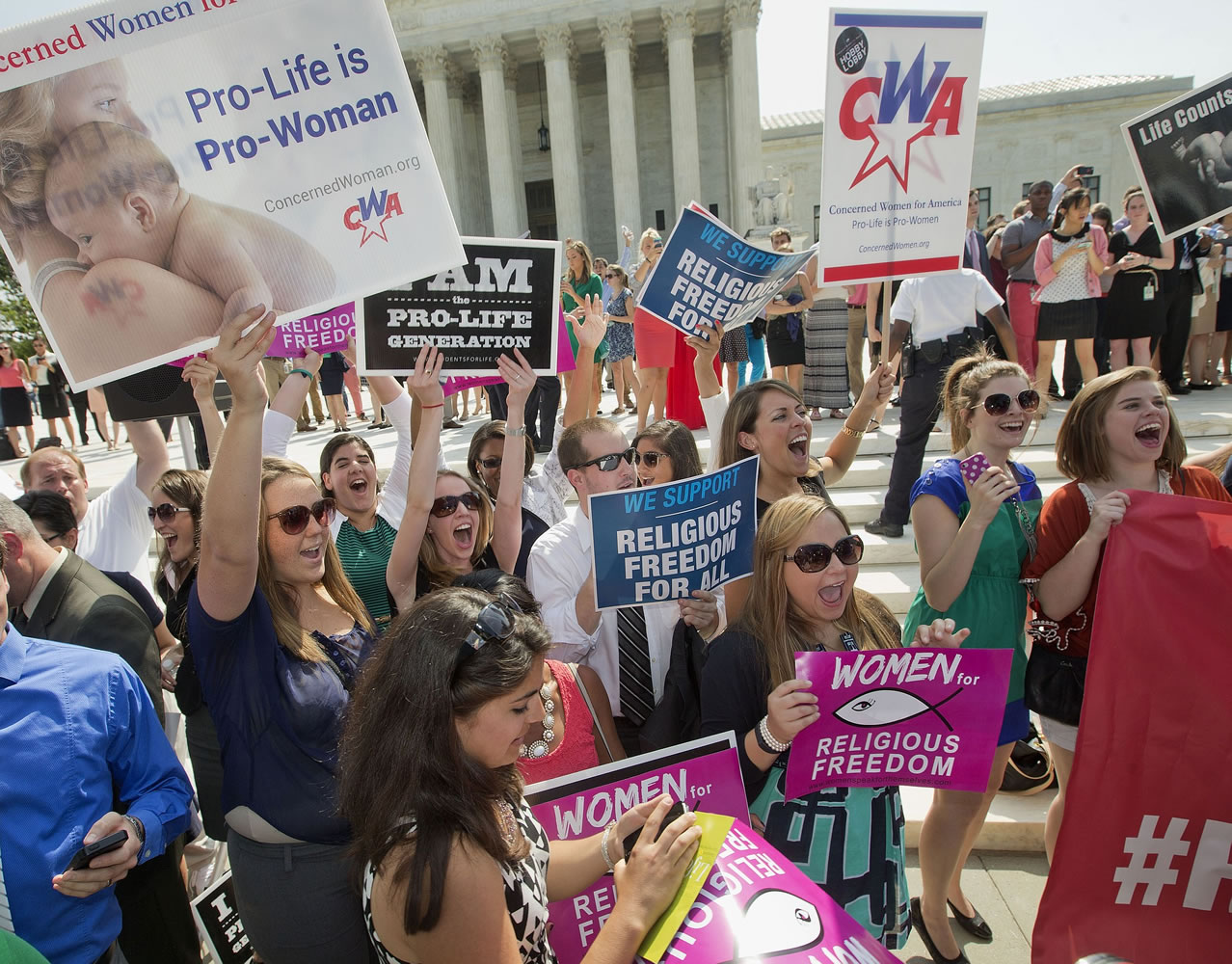 Demonstrators react to hearing the Supreme Court's decision on the Hobby Lobby case outside the Supreme Court in Washington on Monday.