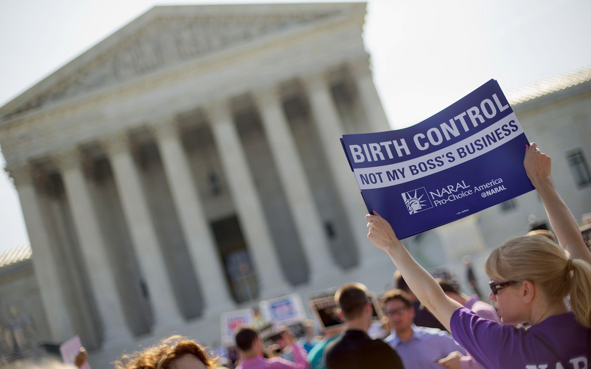 A demonstrator holds up a sign June 30 outside the Supreme Court in Washington on the day the court decided in the Hobby Lobby case to relieve businesses with religious objections of their obligation to pay for women's contraceptives among a range of preventive services the new health law calls for in their health plans.