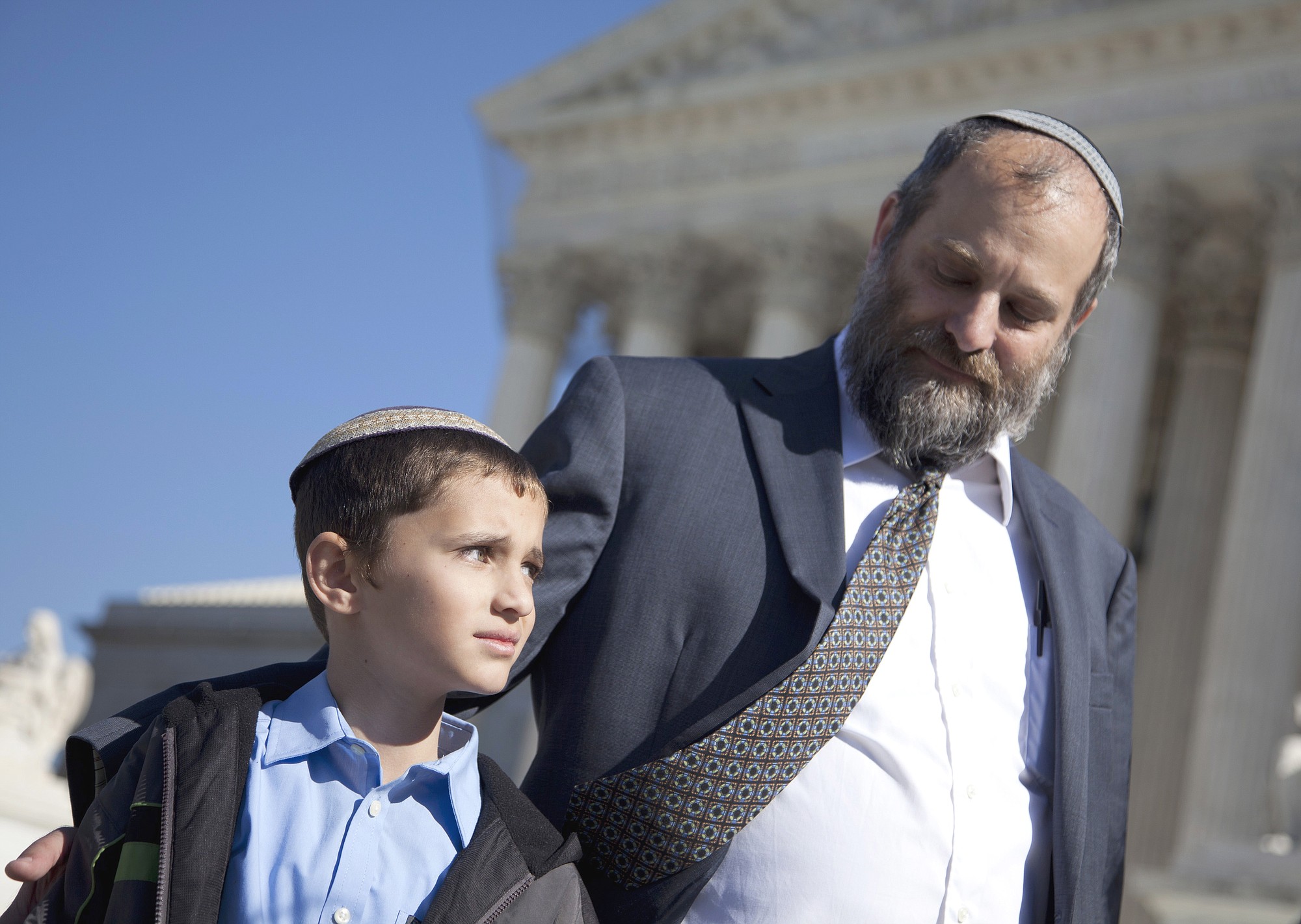 Ari Zivotofsky, right, stands with his 9-year-old son, Menachem, outside the Supreme Court in Washington in 2011. The first time Menachem's case was in front of the Supreme Court, Justice Stephen Breyer laid out several reasons why courts should stay out of a dispute between Congress and the president over whether Americans born in Jerusalem may list their place of birth on their passports as Israel.