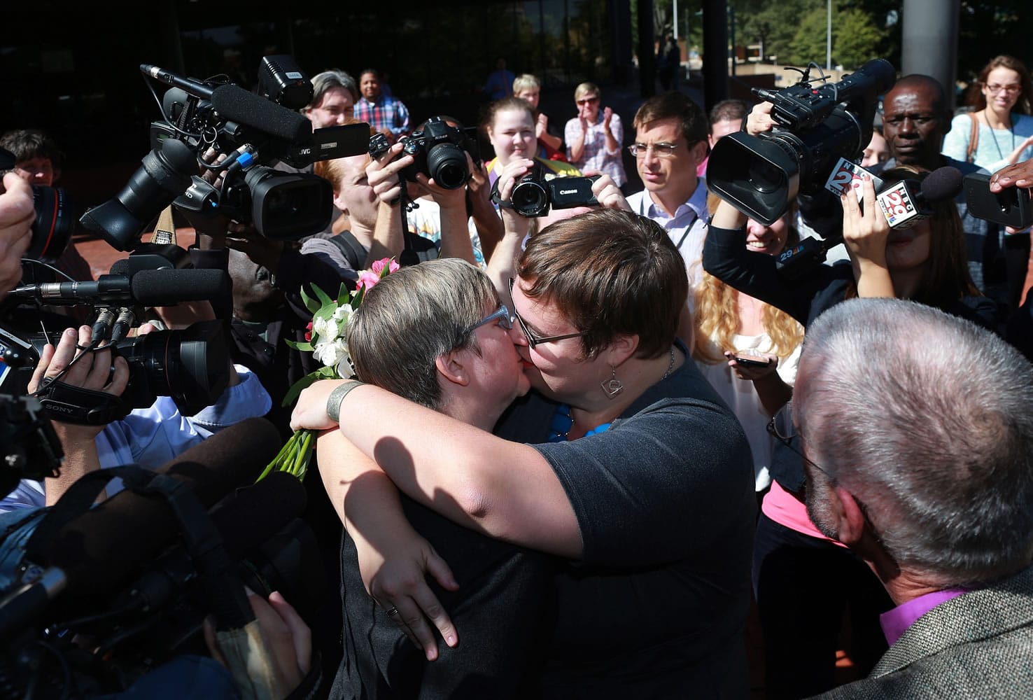 Nicole Pries, center left, and Lindsey Oliver of Richmond kiss each other as they celebrate their same-sex marriage outside of the John Marshall Courts Building in Richmond, Va., on Monday.