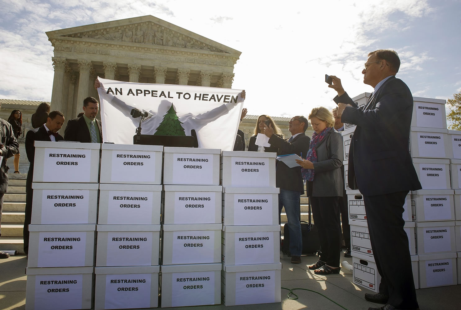 A flag is held over a stack of sixty boxes containing copies of an appeal filed with the Supreme Court, during a Restrain the Judges news conference Monday in front of the Supreme Court in Washington,.