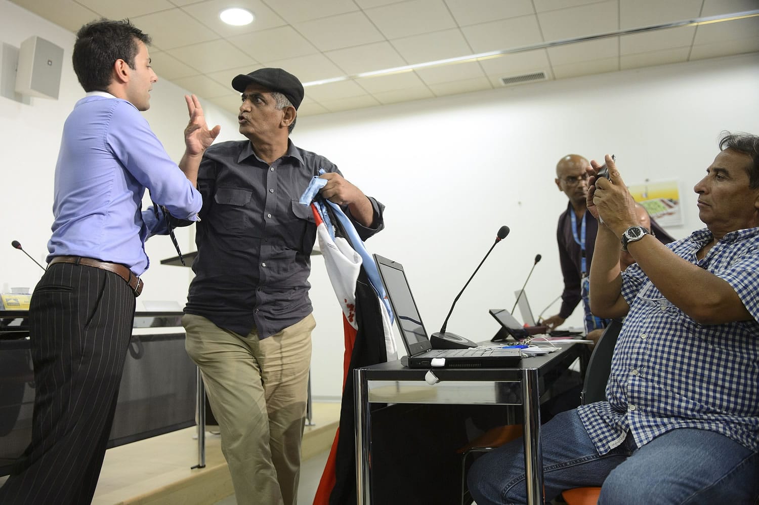 An opposition protester argues with an official during a press conference for the head of the rebel's delegation on Yemen peace talks at the Geneva Press Club in Geneva, Switzerland, on Thursday.