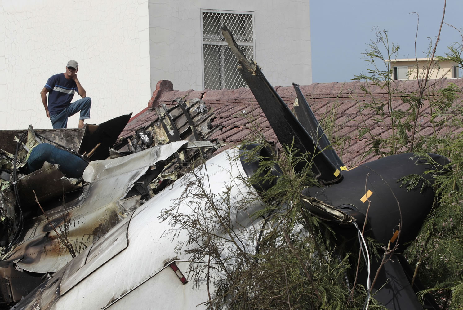 A resident watches the forensic investigation among the wreckage of crashed TransAsia Airways flight GE222 on the outlying island of Penghu, Taiwan, on Thursday.