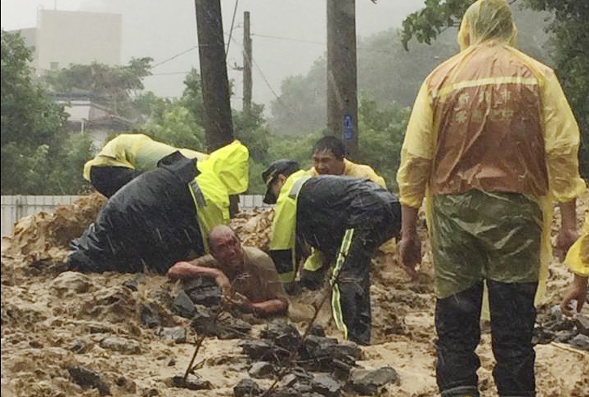 Rescue personnel dig a man from a flash mudslide caused by Typhoon Soudelor on Saturday in Xindian, New Taipei City, Taiwan.
