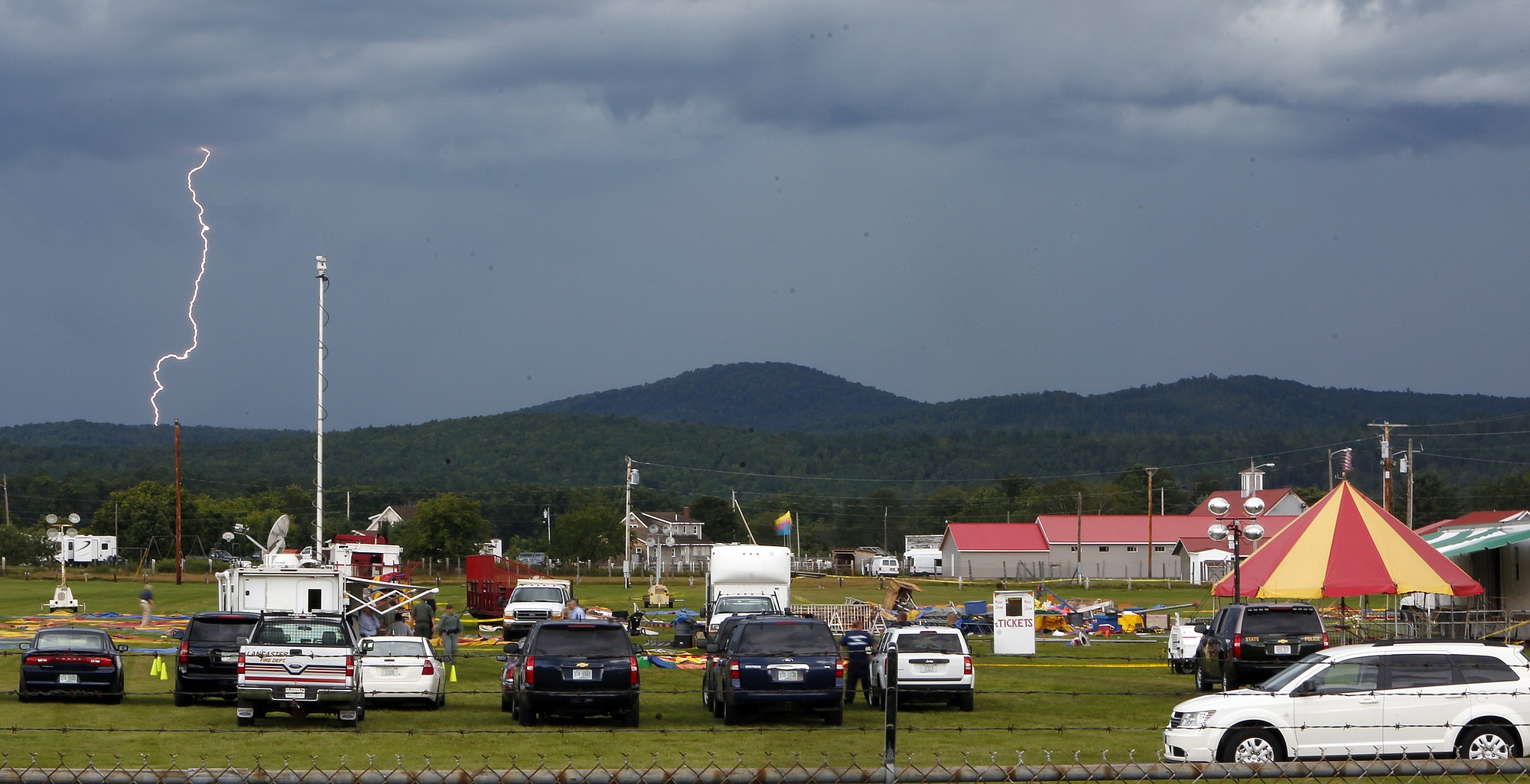 JIM COLE/Associated Press
A storm moves in Tuesday in Lancaster, N.H., as investigators inspect the site of a circus tent that collapsed Monday during a show by the Walker Brothers International Circus.