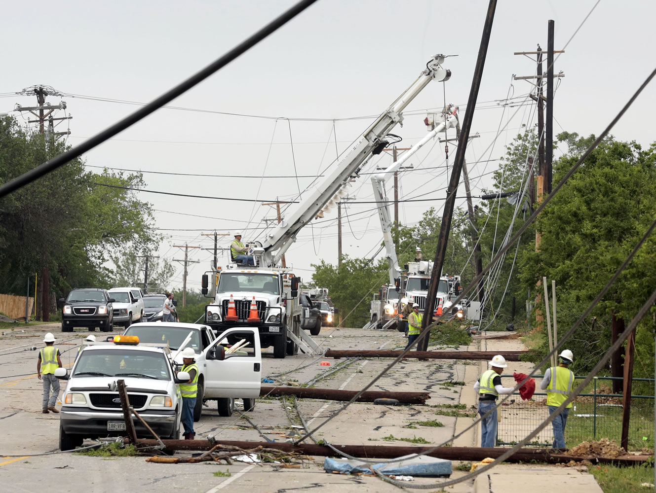 Utility workers try to restore electric power on down lines on Thursday, May 16, 2013, in Cleburne, Texas. A rash of tornadoes slammed into several small communities in North Texas overnight, leaving at least six people dead, dozens more injured and hundreds homeless.