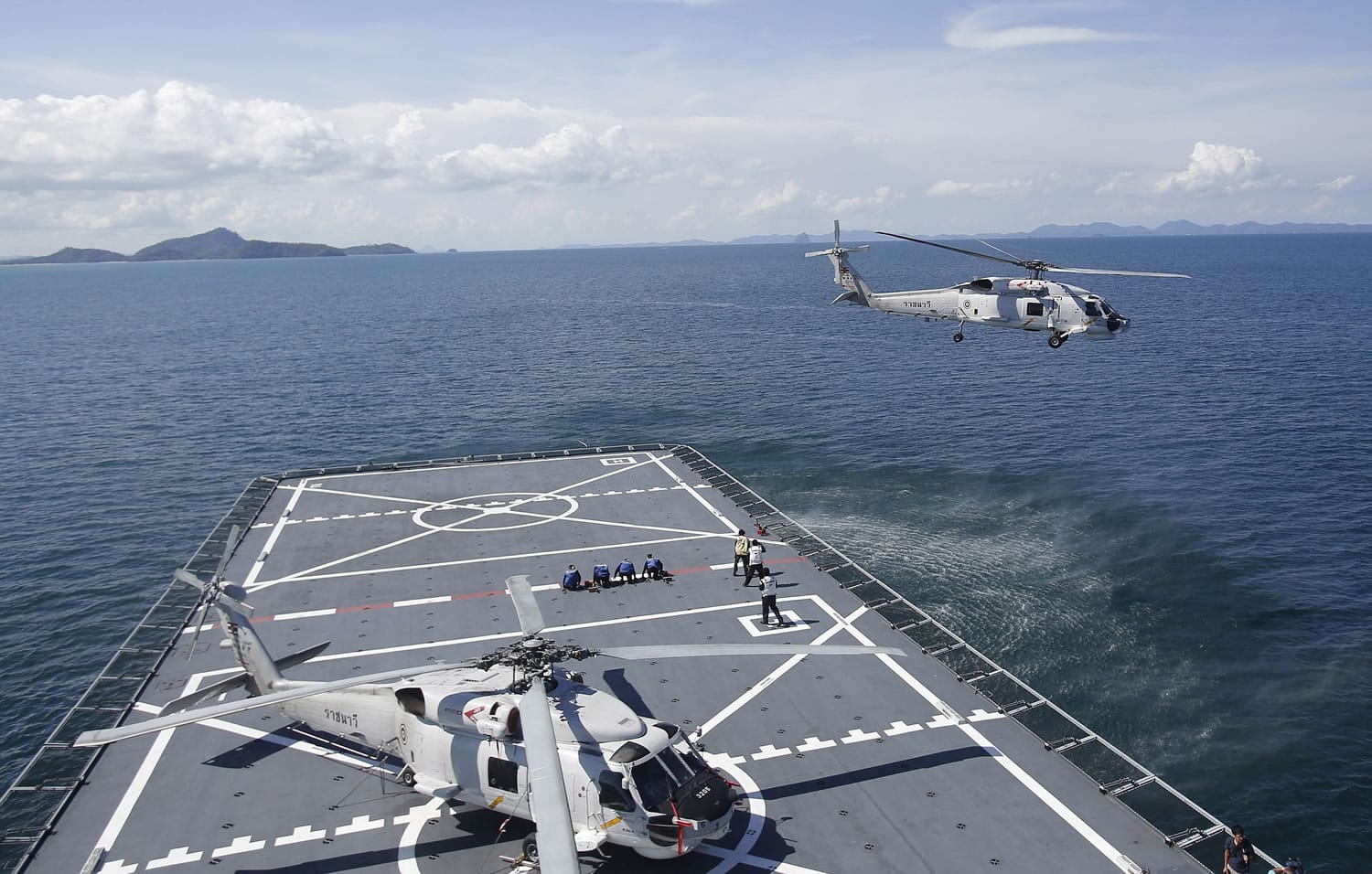 A helicopter takes off from HTMS Angthonga helipad before a patrol demonstration to the media on a Thai naval ship in Phuket province Friday, May 29, 2015. The ship will serve as a floating base to support the Thai navy's mission to search and give humanitarian assistance to the migrants drifting on boats near the Thai maritime border.