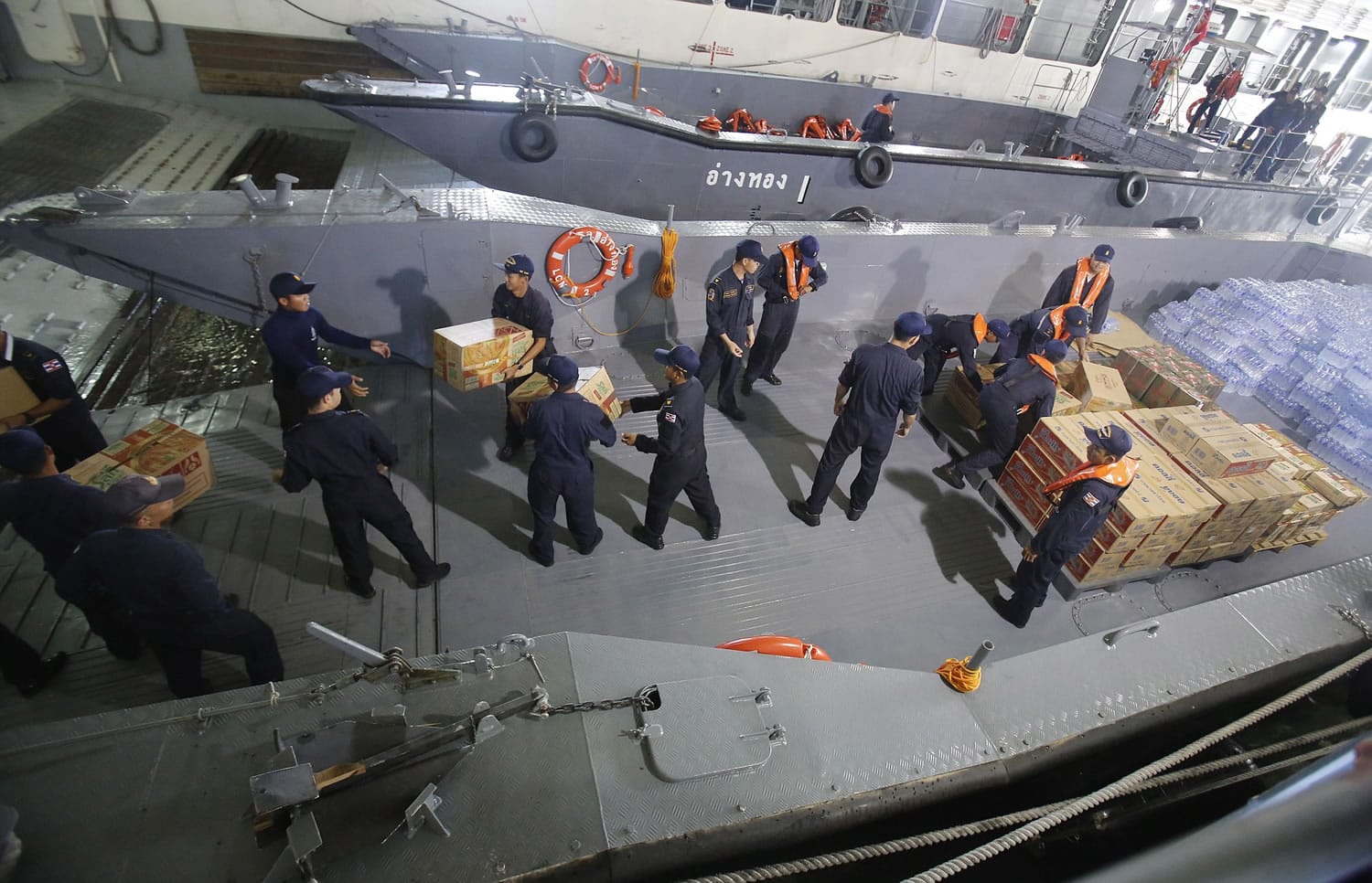 Thai navy officers load food and water onto the HTMS Angthong of the Royal Thai navy on Friday.