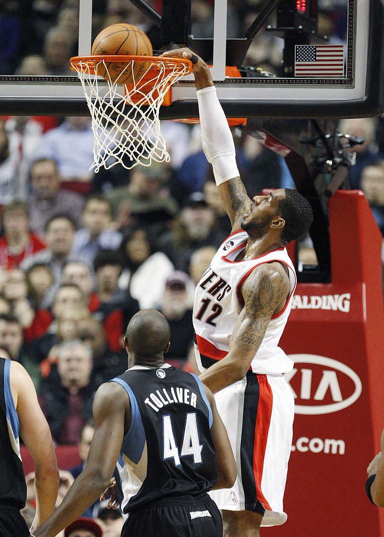 Portland Trail Blazers' LaMarcus Aldridge (12) dunks the ball as Minnesota Timberwolves' Anthony Tolliver (44) looks on in the first quarter Monday at the Rose Garden.