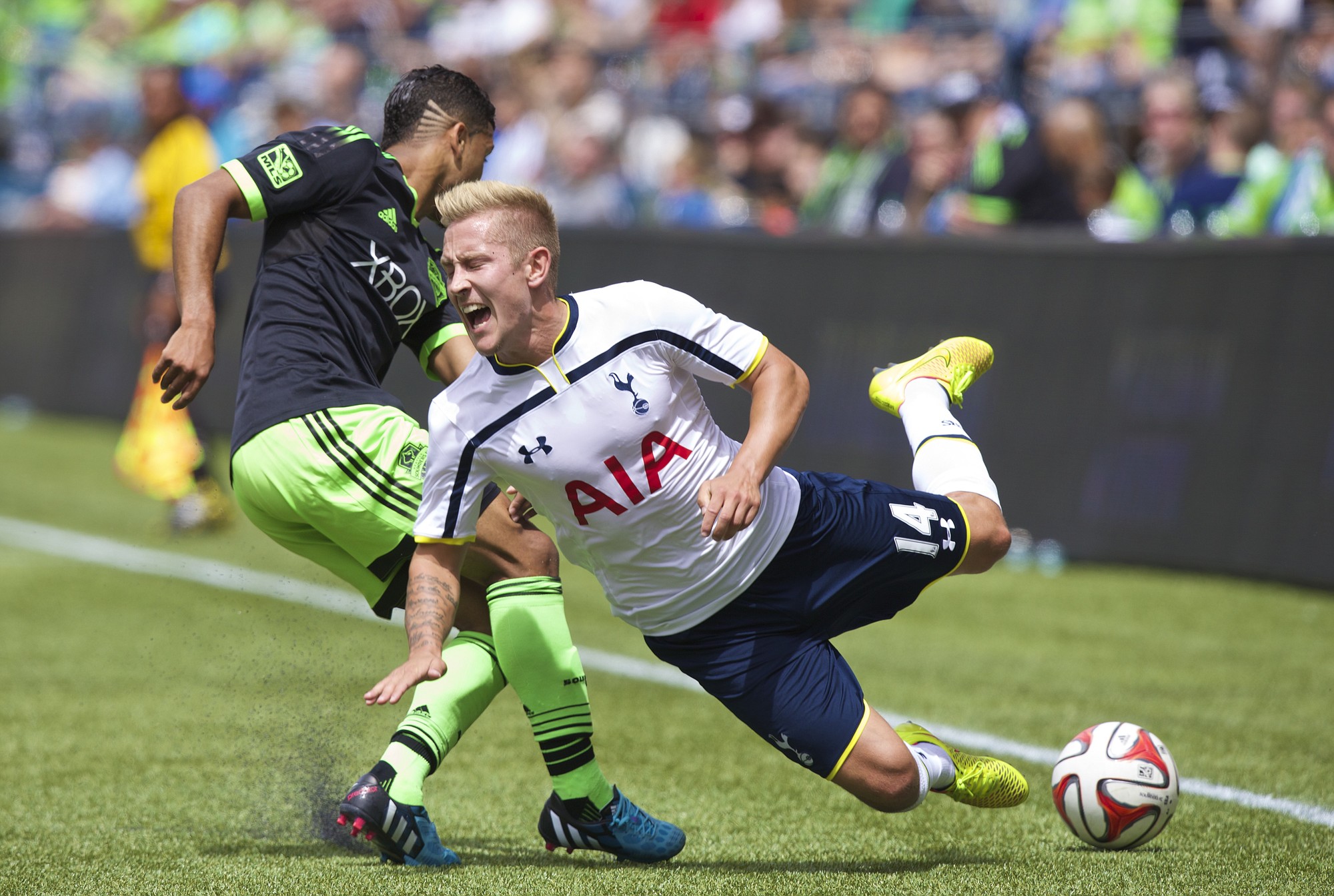 Tottenham Hotspur's Lewis Holtby (14) is tackled by Seattle Sounders' DeAndre Yedlin during the first half of a soccer match Saturday in Seattle.