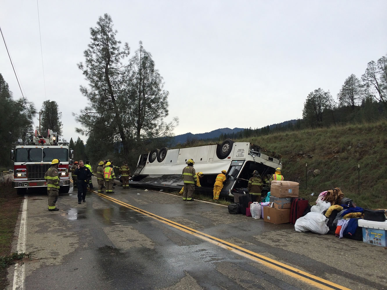 Emergency personnel check a tour bus that had already crashed earlier in the day overturned just off Interstate 5 in Northern California, killing one person and sending dozens to hospitals near the Pollard Flat area in Redding, Calif., Sunday, Nov. 23, 2014.