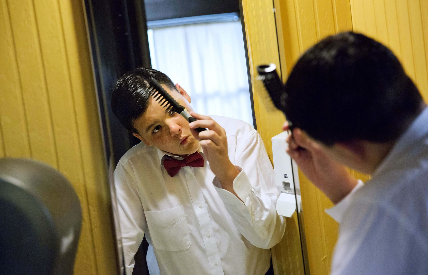 Photos by DAVID GOLDMAN/Associated Press
Camper Colin Billings, 12, of Yorktown, Va., combs his hair Thursday before attending a dance on the final night at Camp Twitch and Shout, a camp for children with Touretteu2019s Syndrome in Winder, Ga. It was the first time Billings asked a girl to a dance. She said yes.