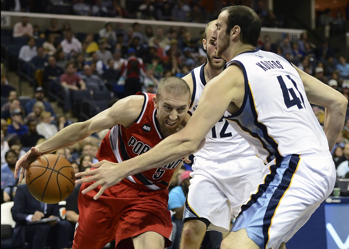 Portland Trail Blazers guard Steve Blake (5) is fouled by going the the basket by Memphis Grizzlies center Kosta Koufos (41) in the first half of an NBA basketball game Saturday, March 21, 2015, in Memphis, Tenn.