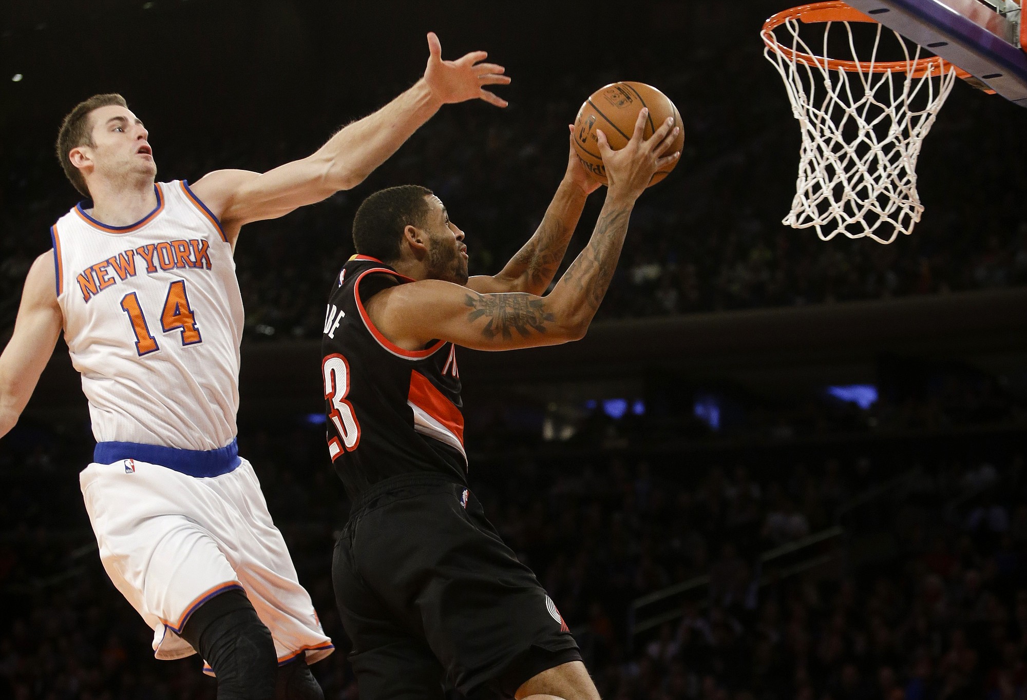 Portland's Allen Crabbe (23) drives past New York's Jason Smith (14) during the first half Sunday, Dec. 7, 2014, in New York.