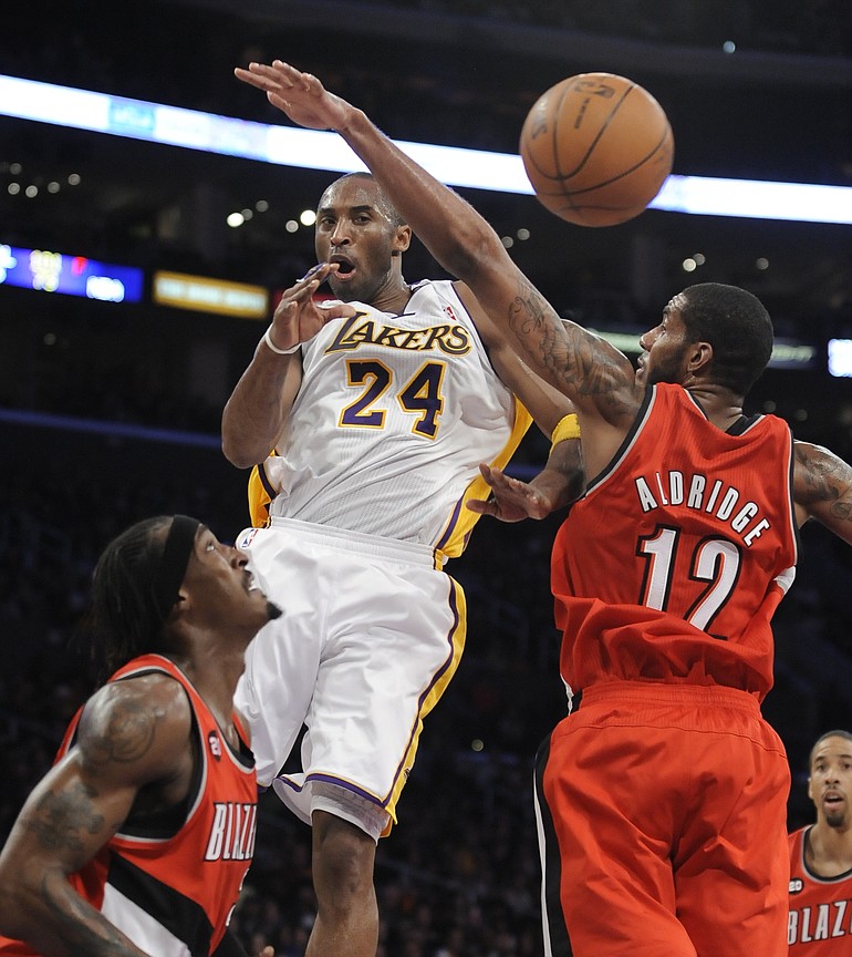 Los Angeles Lakers guard Kobe Bryant (24) gets the pass off between Portland Trail Blazers forward Gerald Wallace, left, and forward LaMarcus Aldridge (12).