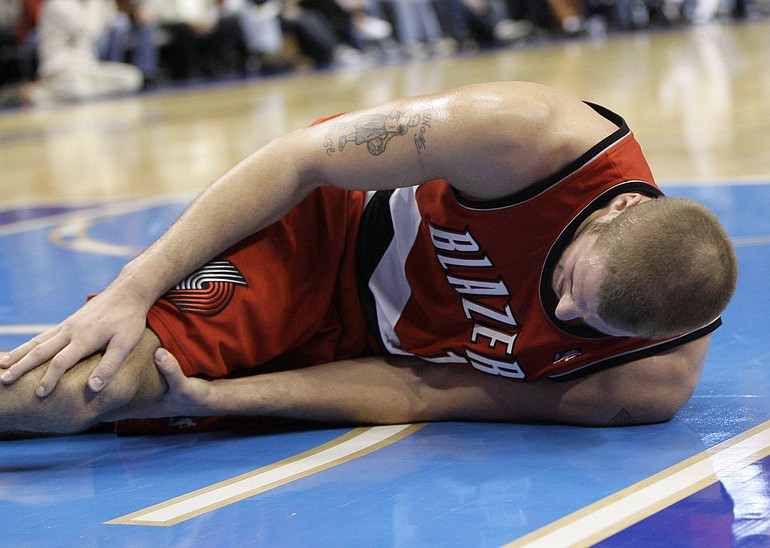 Portland Trail Blazers center Joel Przybilla grabs his knee in the first half of an NBA basketball game against the Dallas Mavericks, Tuesday.