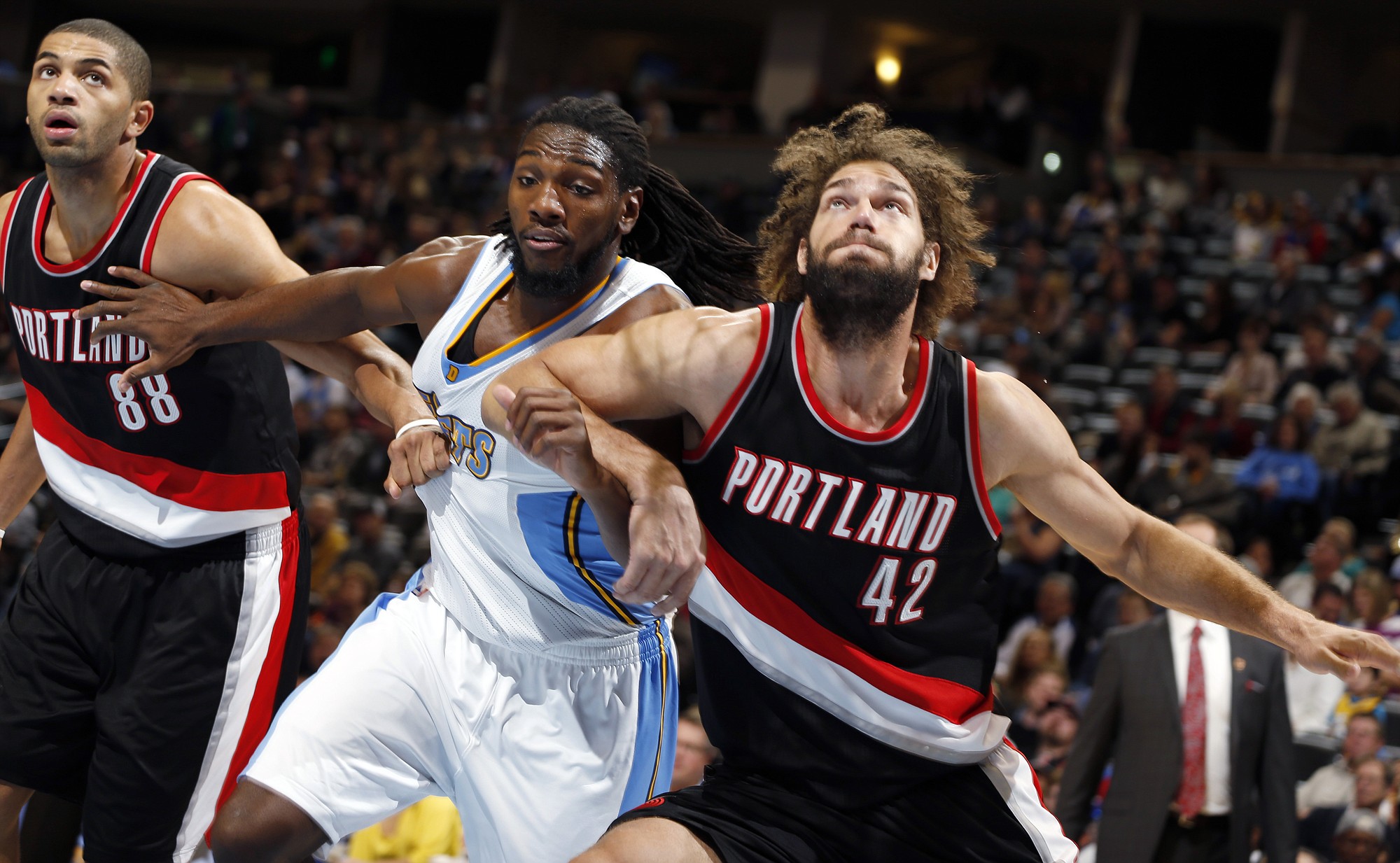 Portland Trail Blazers center Robin Lopez, right, boxes out Denver Nuggets forward Kenneth Faried, center, from a rebound.