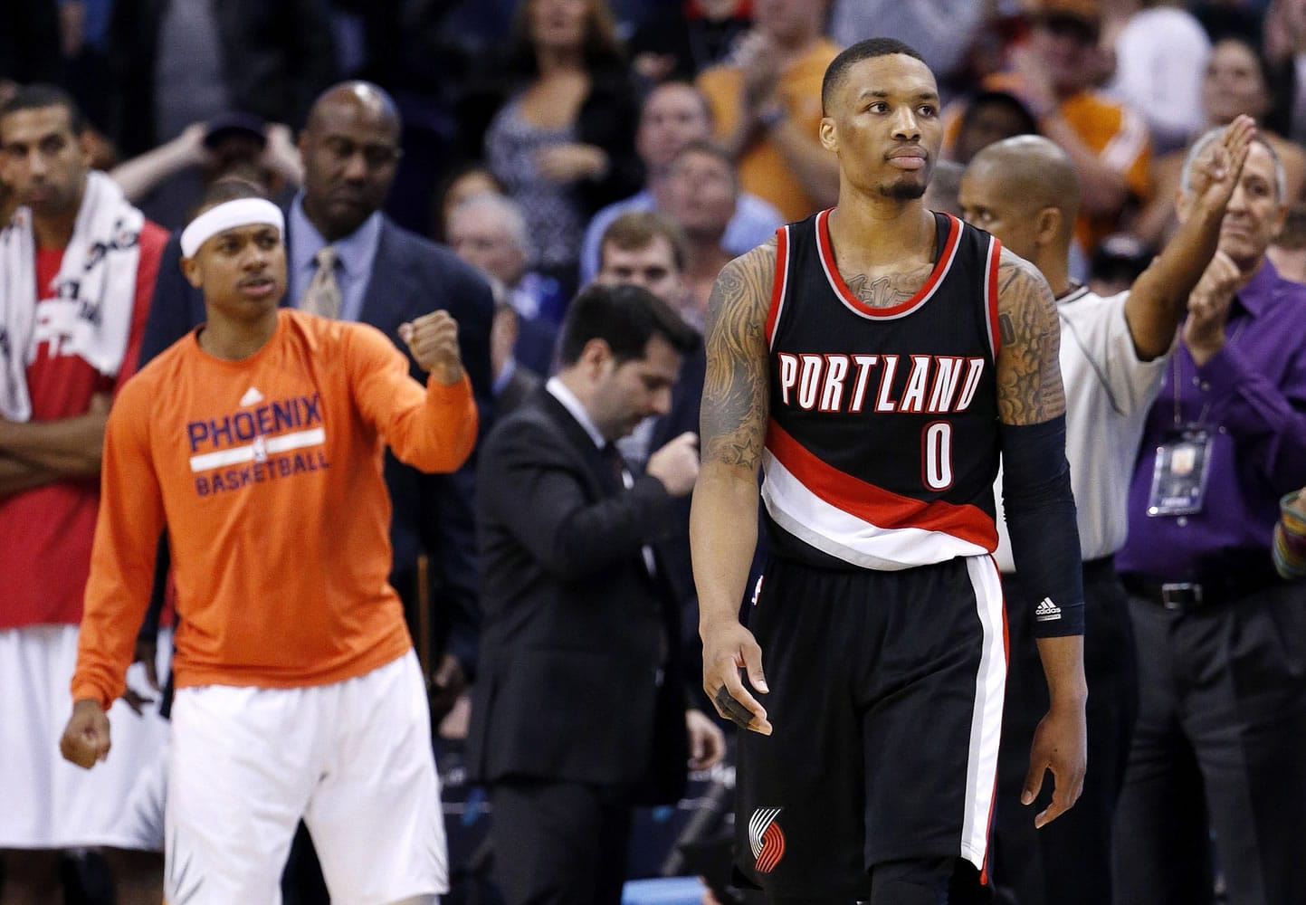 Portland Trail Blazers' Damian Lillard (0) walks away from the Phoenix Suns bench area after he missed a shot, as Suns' Isaiah Thomas, left, pumps his fist in the closing moments of Wednesday's game in Phoenix.