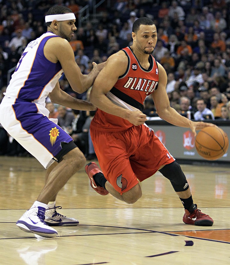 Portland Trail Blazers Brandon Roy drives past Phoenix Suns' Jared Dudley, left, during the first quarter of an NBA basketball game Friday, Dec. 10, 2010, in Phoenix.