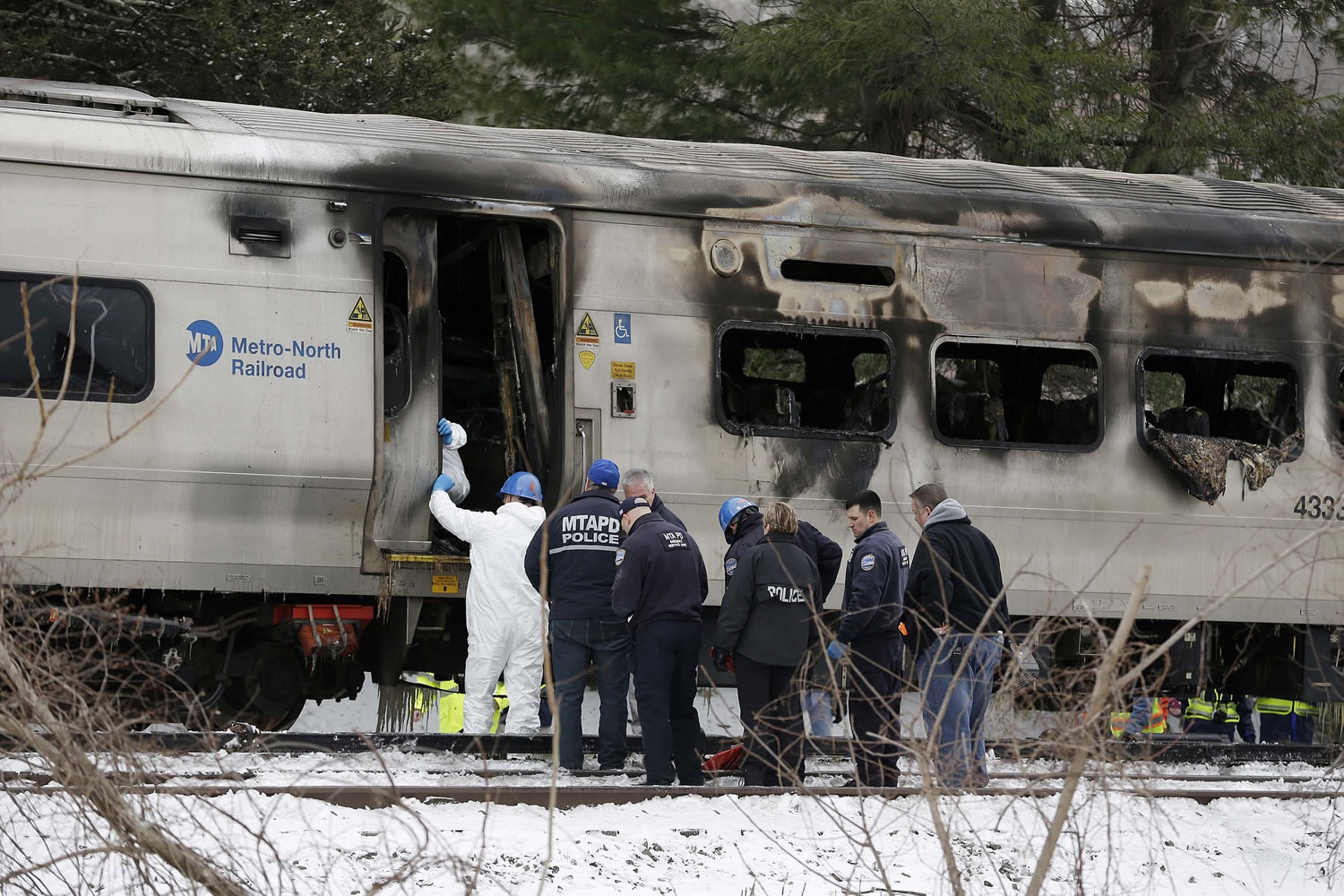 Emergency personnel look over the site of a collision between a Metro-North Railroad train and an SUV in Valhalla, N.Y., on Wednesday.