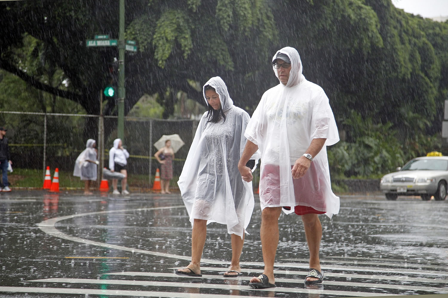 Tourists cope wet weather in Waikiki in Honolulu on Sunday. Hurricane Ana brought a steady rain to the Hawaiian Island of Oahu as it passed about 180 miles west.