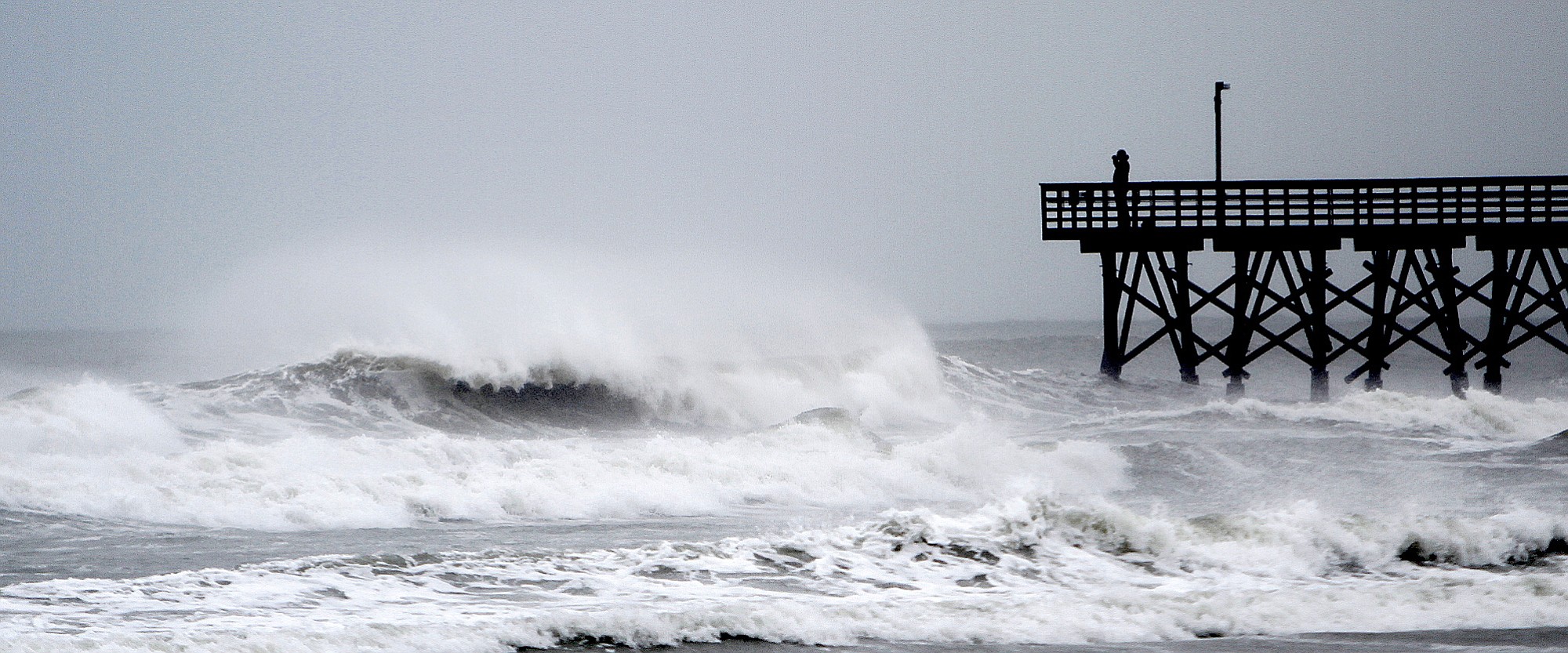 A person stands on the end of the pier Thursday in Cherry Grove Beach, S.C.