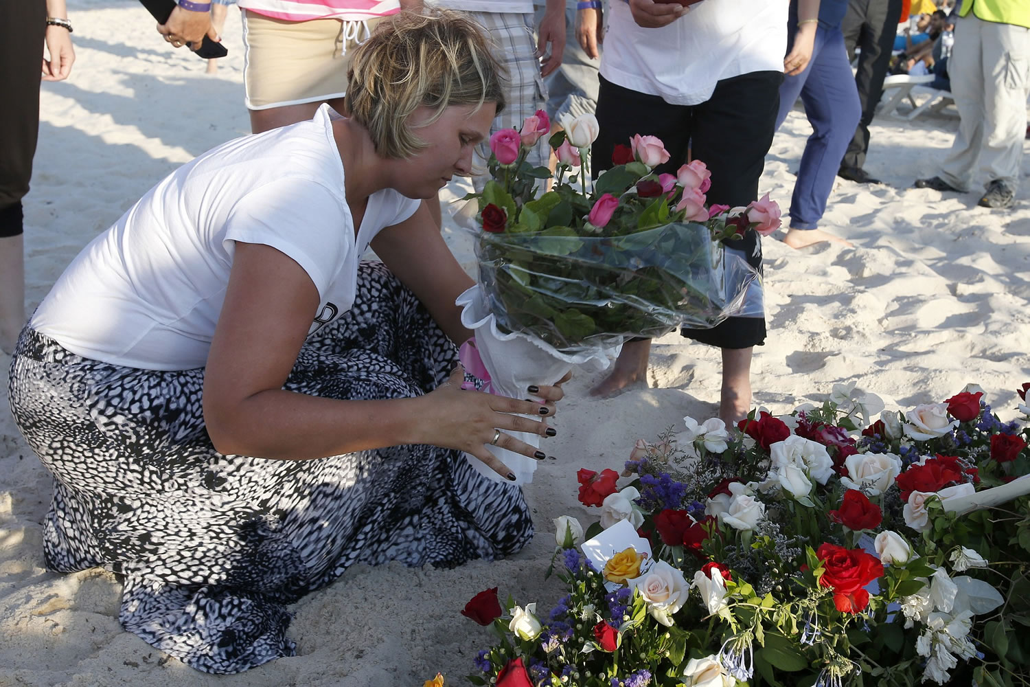 A tourist places flowers Sunday at the scene of Friday's shooting attack in the coastal town of Sousse, Tunisia.