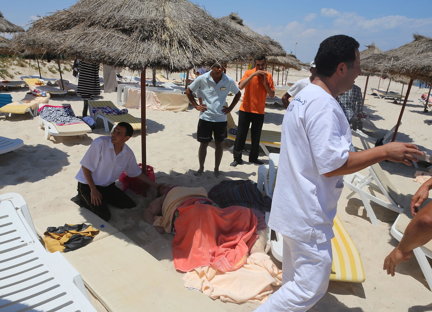 An injured person is treated on a beach Friday in Sousse, Tunisia, where a man opened fire on European sunbathers at a resort.