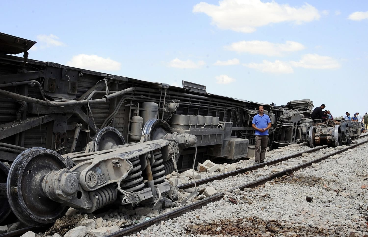 A man stands by a derailed carriage of a train outside Fahs, 37 miles from Tunis, Tunisia, on Tuesday.