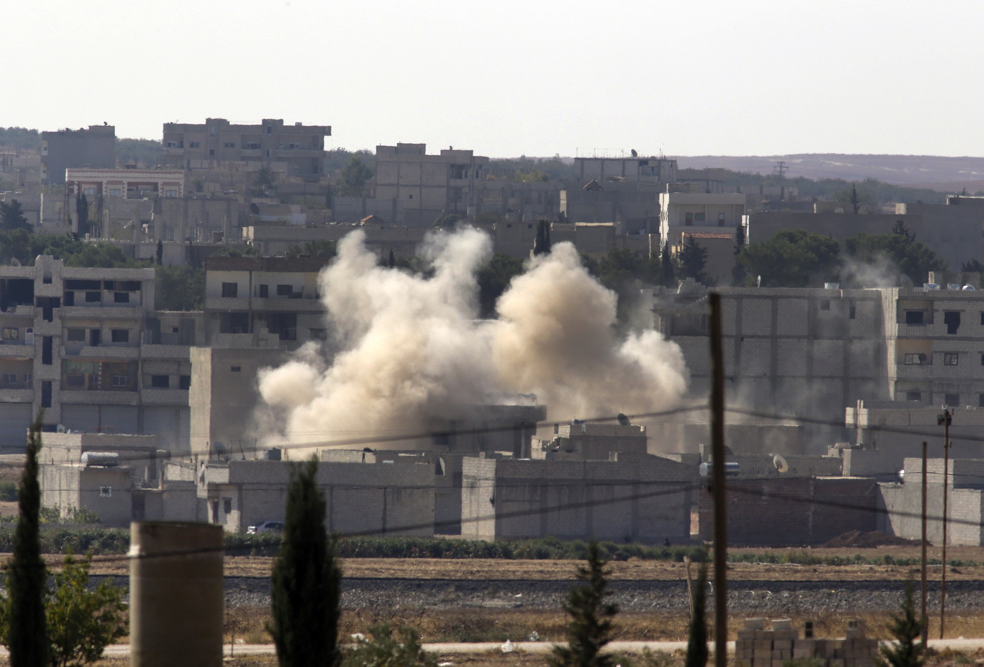 Smoke rises Sunday after a shell landed in Kobani in Syria as fighting intensified between Syrian Kurds and the militants of Islamic State group.