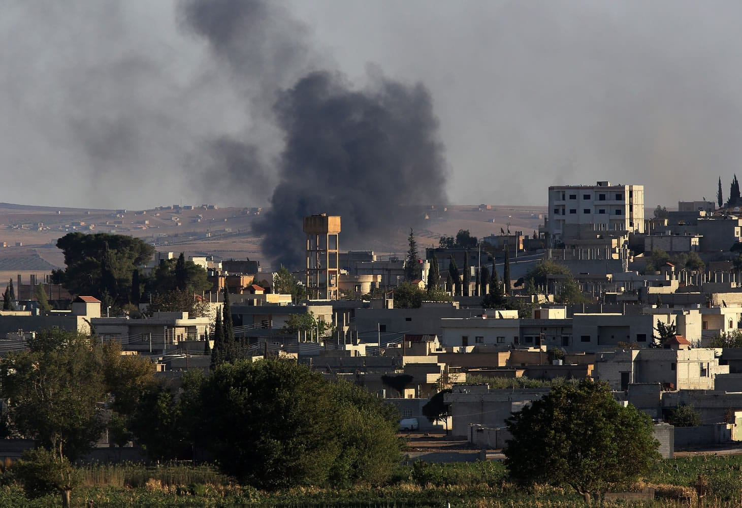 Smoke rises after a mortar shell landed Wednesday south of the city center of the Syrian town of Kobani, near the Turkey-Syria border.