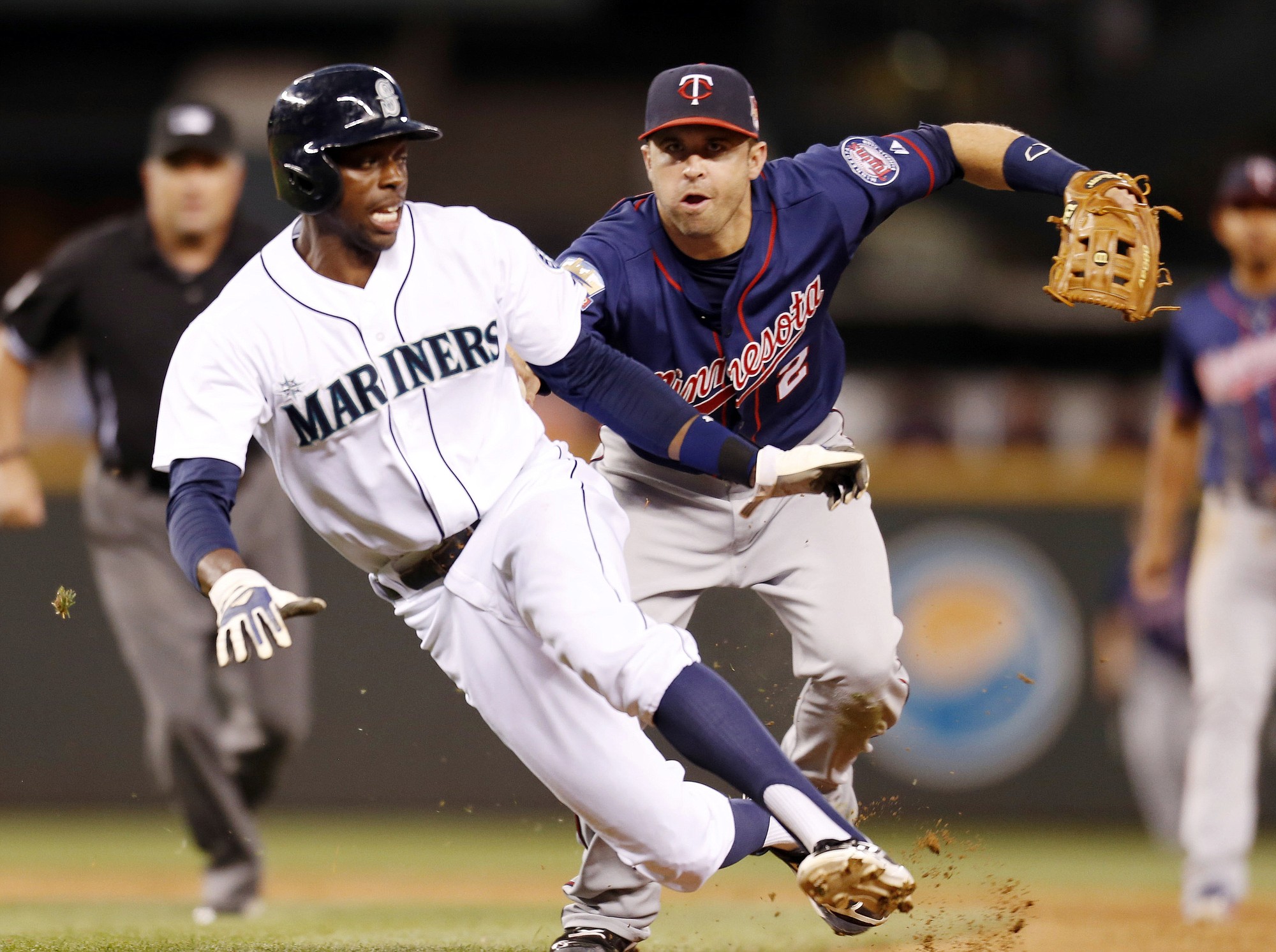 Minnesota Twins second baseman Brian Dozier, right, tags Seattle Mariners' James Jones out as Robinson Cano grounds out into a double play during the eighth inning Tuesday.