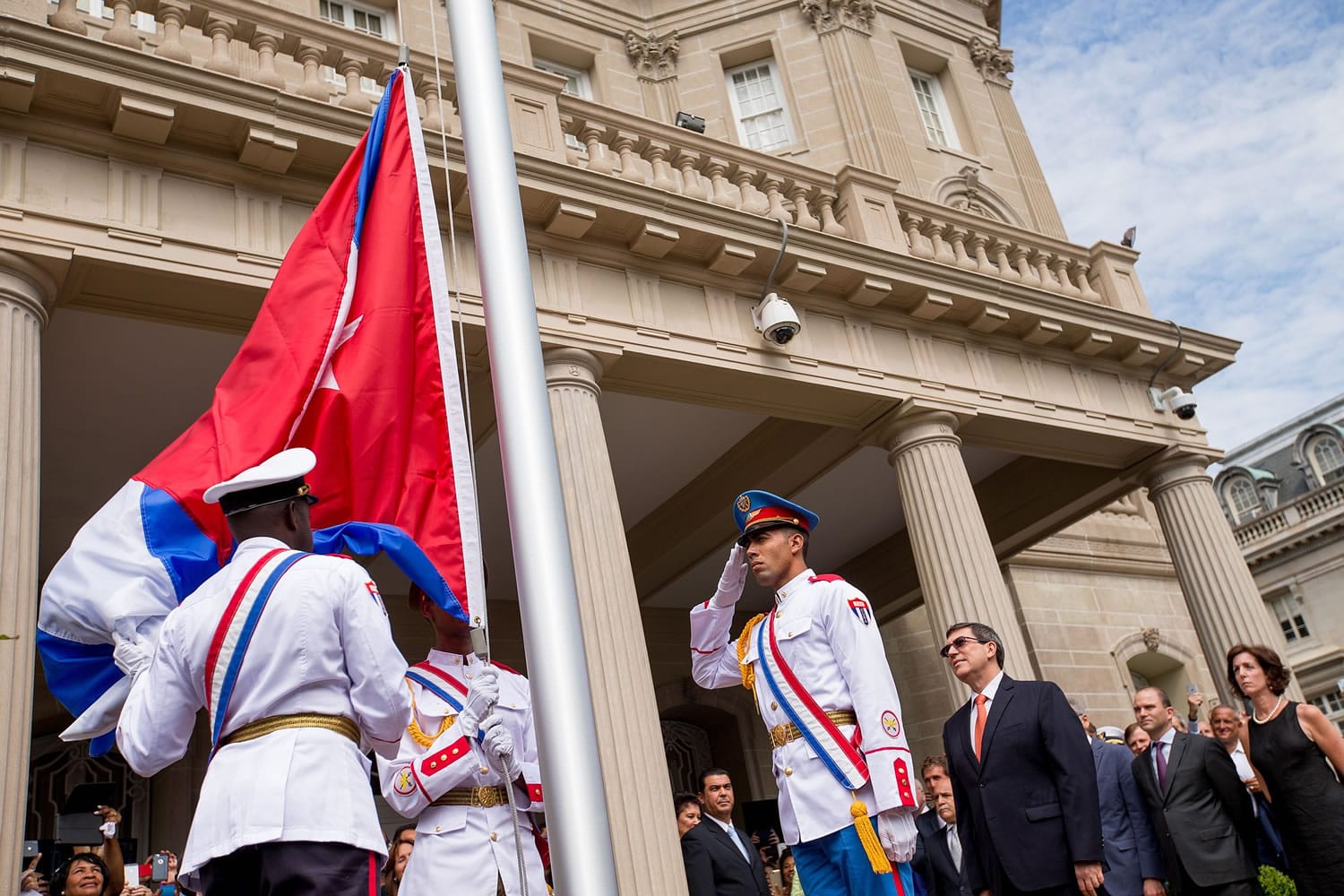A Cuban honor guard prepares the Cuban flag for Cuban Foreign Minister Bruno Rodriguez, center right, before he raises the Cuban flag over their new embassy in Washington on Monday.
