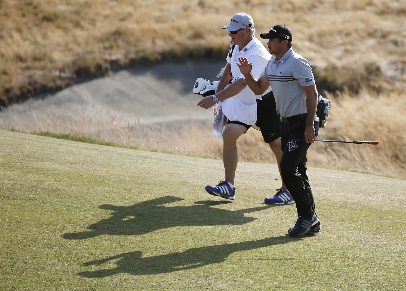 Jason Day walks up to the 18th green with his caddie Colin Swatton during third round of the U.S. Open at Chambers Bay on Saturda in University Place. Day is tied for the lead at 4-under par despite suffering from vertigo during the past two rounds.