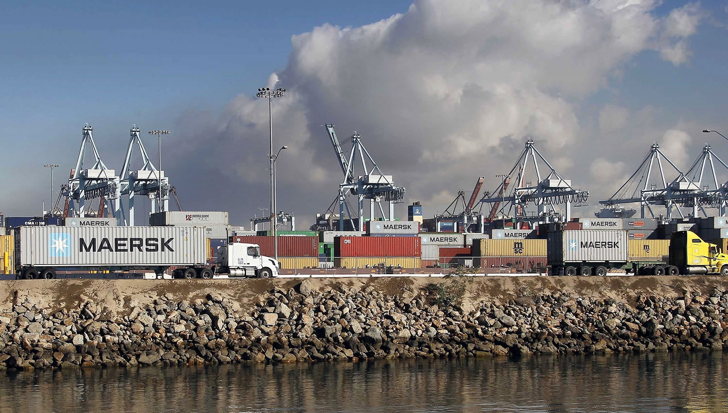 Nick Ut/Associated Press
Tractor-trailers hauling containers leave the Port of Los Angeles on Monday. Nearly all West Coast seaports began the week with dockworkers hustling to load and unload cargo ships that were held up amid a months-long labor-management dispute.
