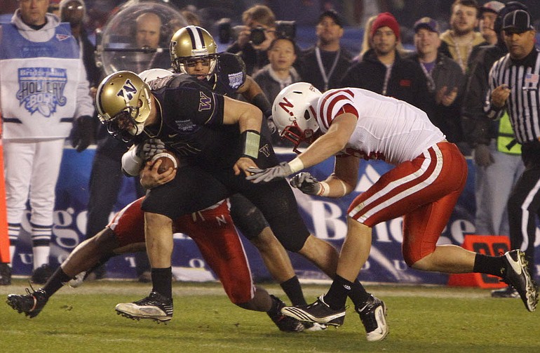 Washington quarterback Jake Locker breaks through two Nebraska defenders while running 25 yards for a touchdown during the second half of the Holiday Bowl.