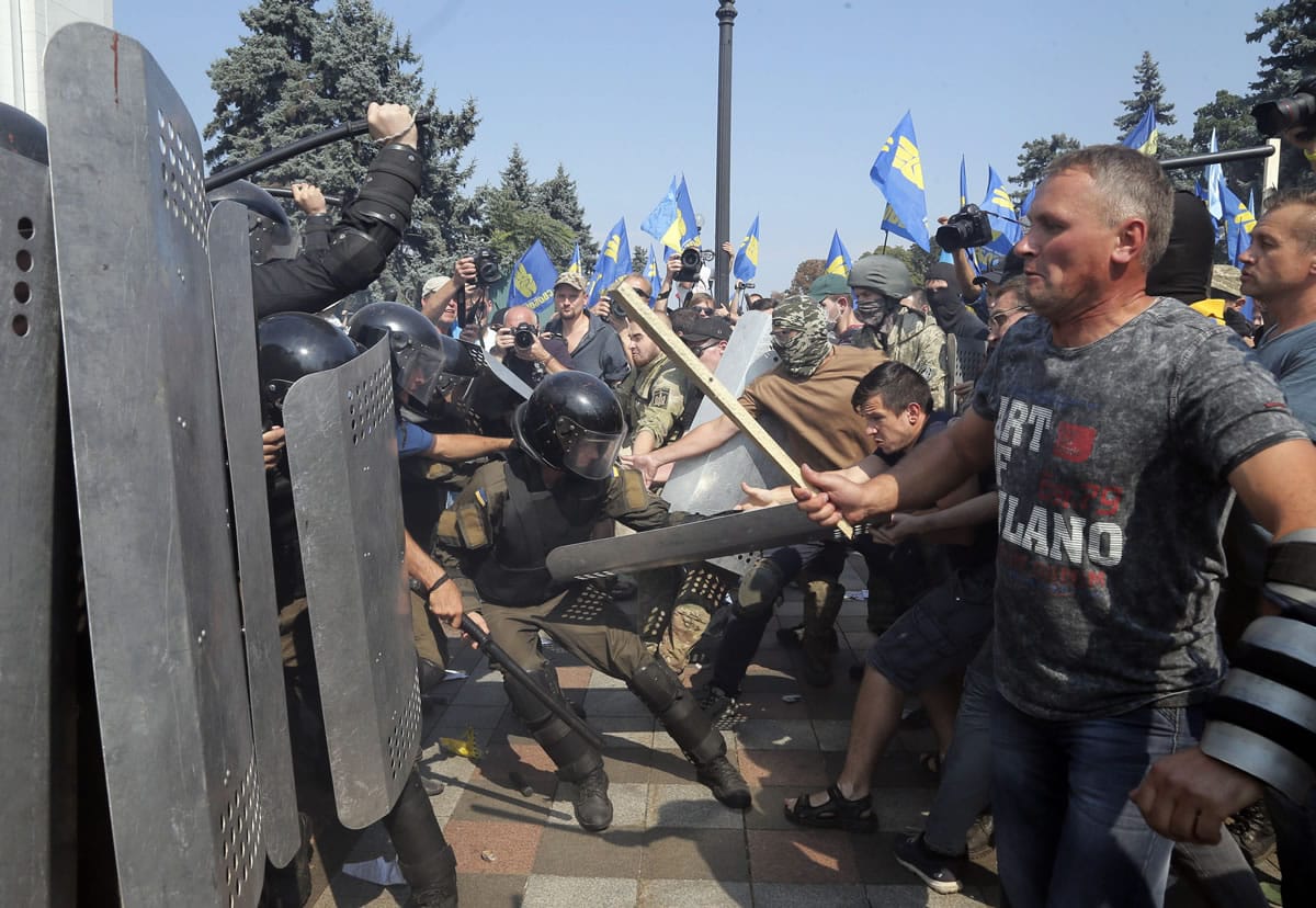 Ukrainian protesters clash with police after a vote to give greater powers to the east, outside the Parliament, Kiev, Ukraine, Monday, Aug. 31, 2015. The Ukrainian parliament has given preliminary approval to a controversial constitutional amendment that would provide greater powers to separatist regions in the east. Hundreds of people gathered in front of the parliament to protest against the amendment.