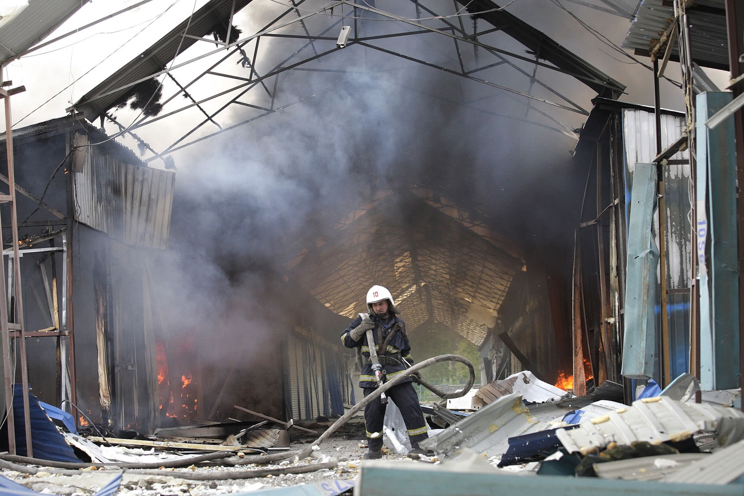 A firefighter works to put out a fire at a market that was destroyed after shelling Wednesday in Donetsk, Ukraine.