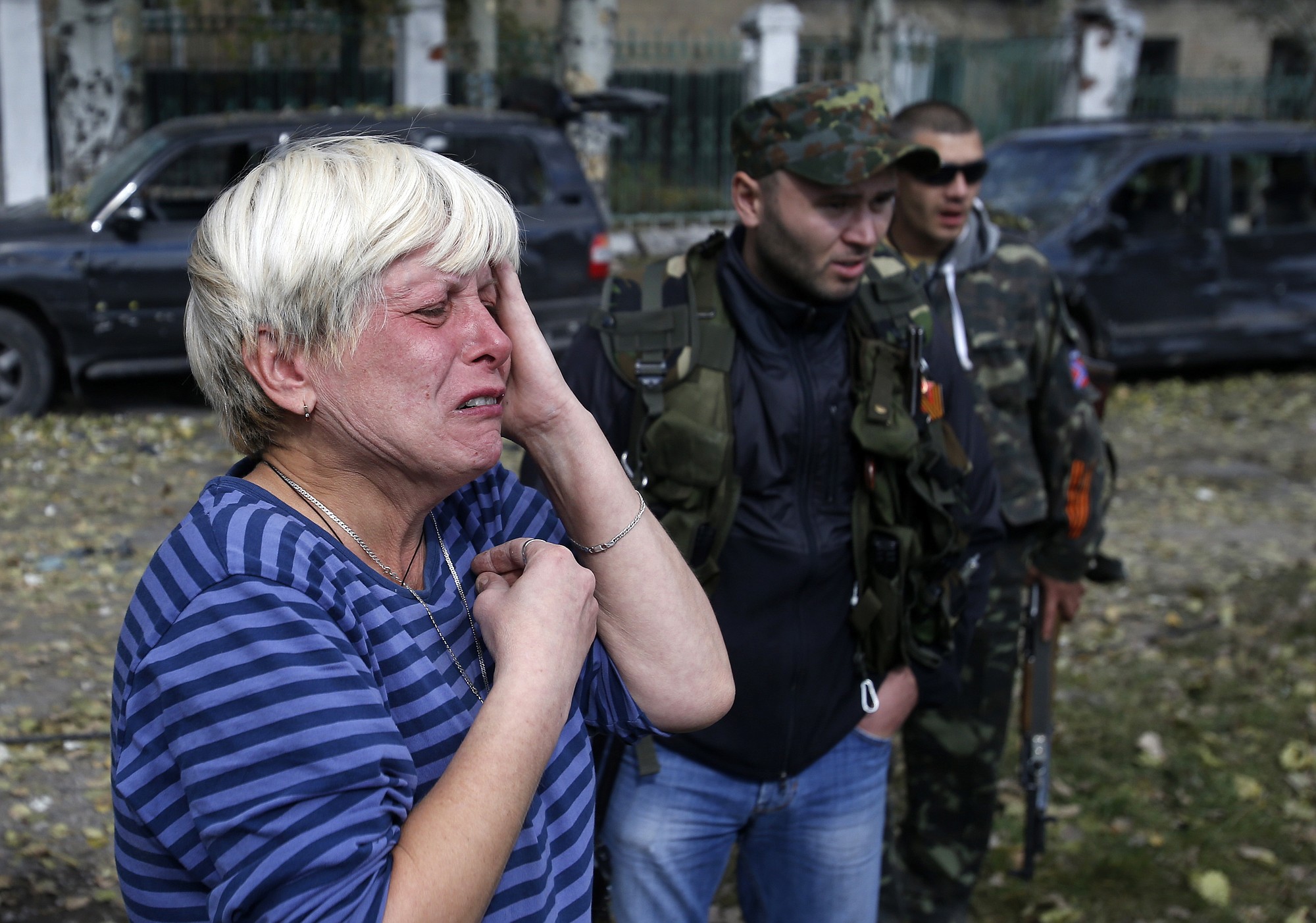 A woman cries in front of a damaged school after shelling Wednesday in Donetsk, Ukraine.