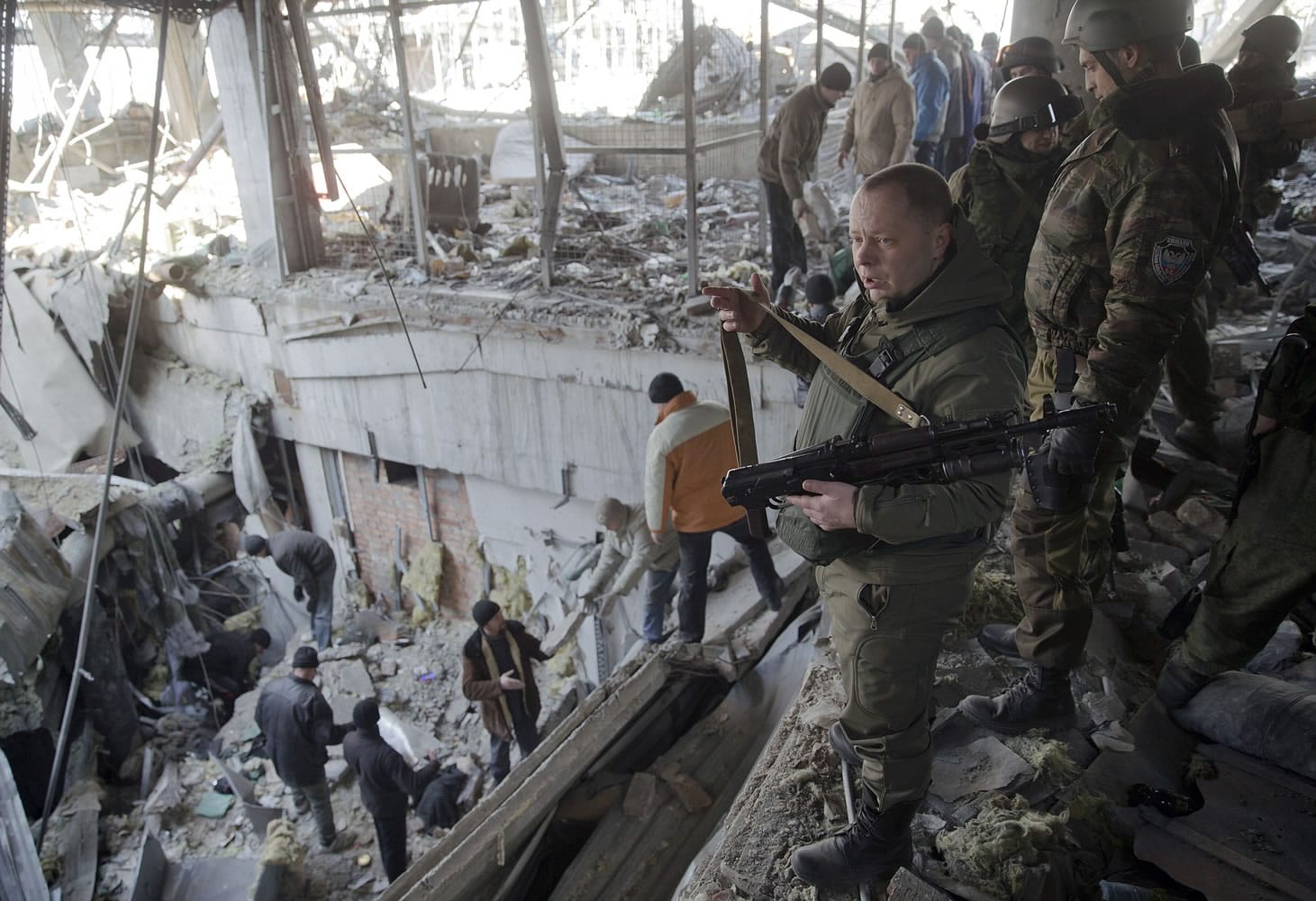 Vladimir Kononov, defense minister of the self-proclaimed Donetsk People's Republic, looks on as Ukrainian prisoners of war clear rubble Wednesday in a destroyed building of the airport outside Donetsk, Ukraine.
