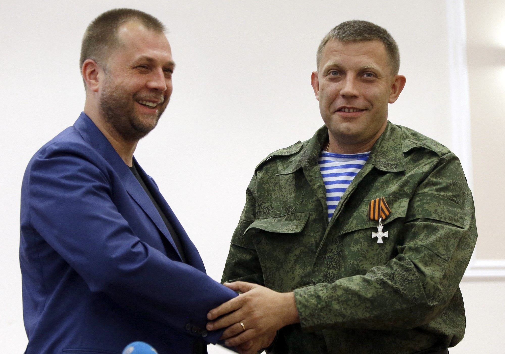 Outgoing Prime Minister Alexander Borodai, left, shakes hands with Alexander Zakharchenko, who has been put forward as the new Prime Minister of the self-declared &quot;Donetsk People?s Republic&quot;, after a press conference in Donetsk, eastern Ukraine,Thursday Aug. 7, 2014. Alexander Borodai announced he was resigning Thursday and that he would act as an adviser to Zakharchenko, once he has been confirmed by the separatist legislature.